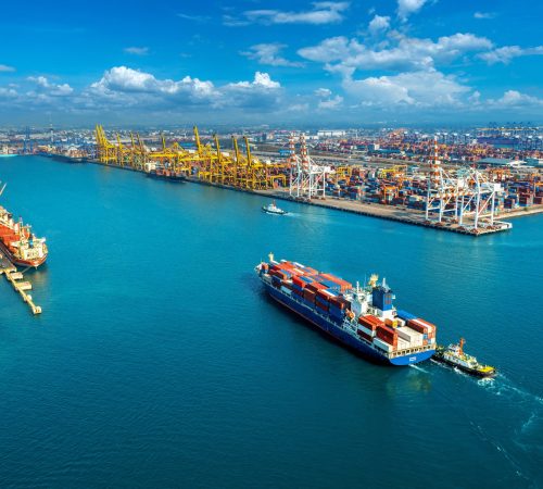 Aerial view of cargo ship and cargo container in harbor.